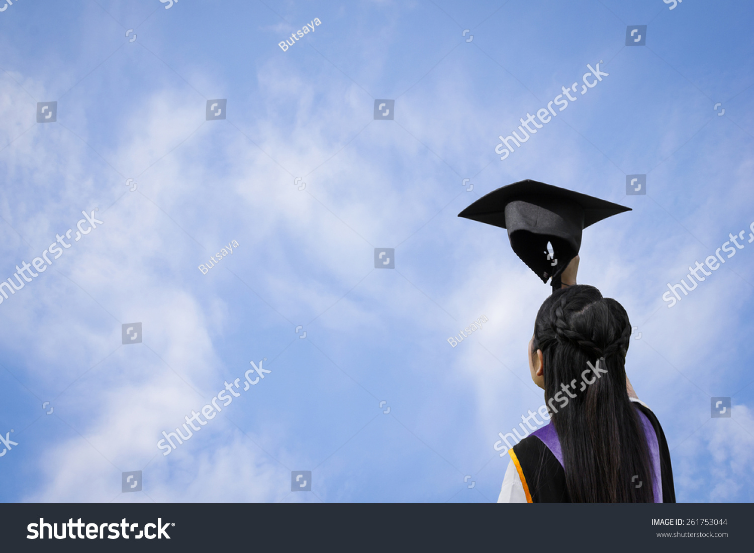 一回头看研究生女孩手拿着帽子向天空。-教育