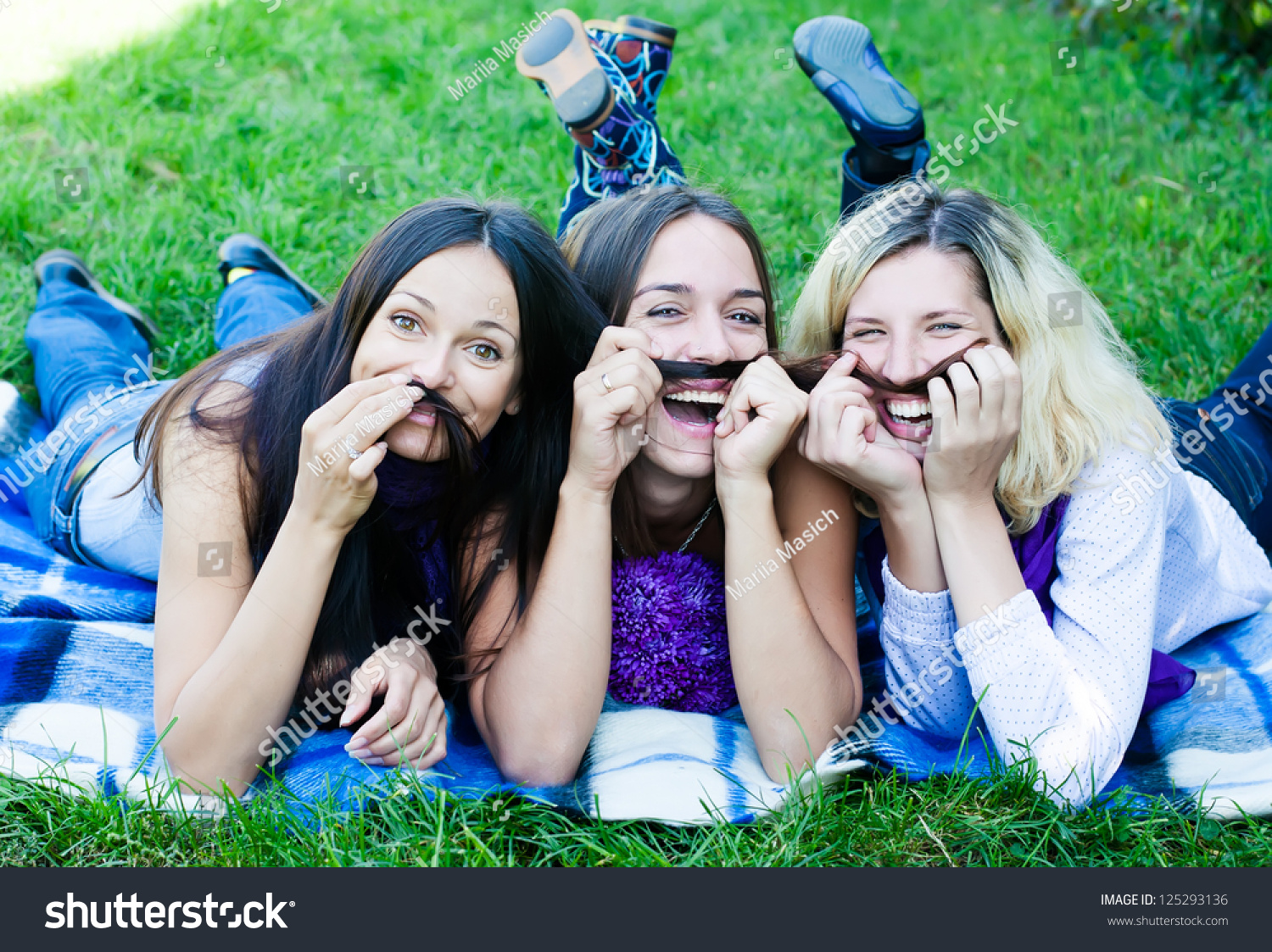girlfriends having fun lounging on the grass-人物,公园/户外-海洛