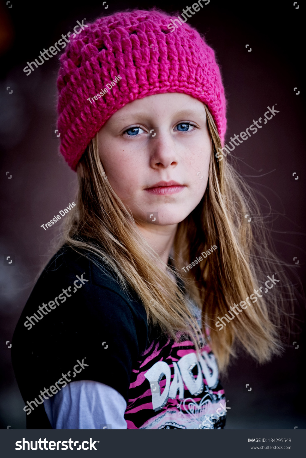 美丽的小女孩严重脸戴着粉色的针织帽子和注视镜头-人物-海洛创意