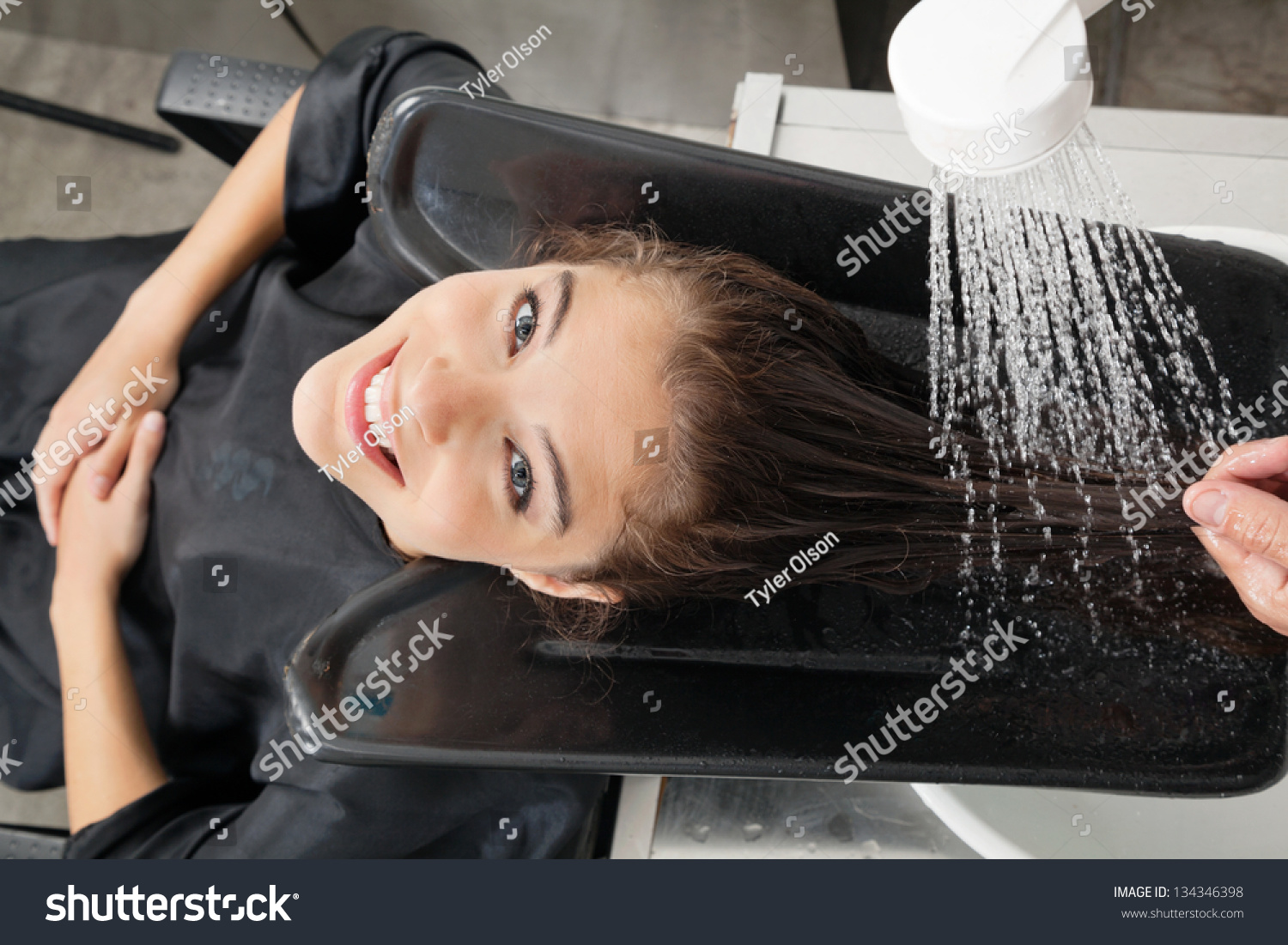 portrait of female client getting hair wash at beauty salon-人物