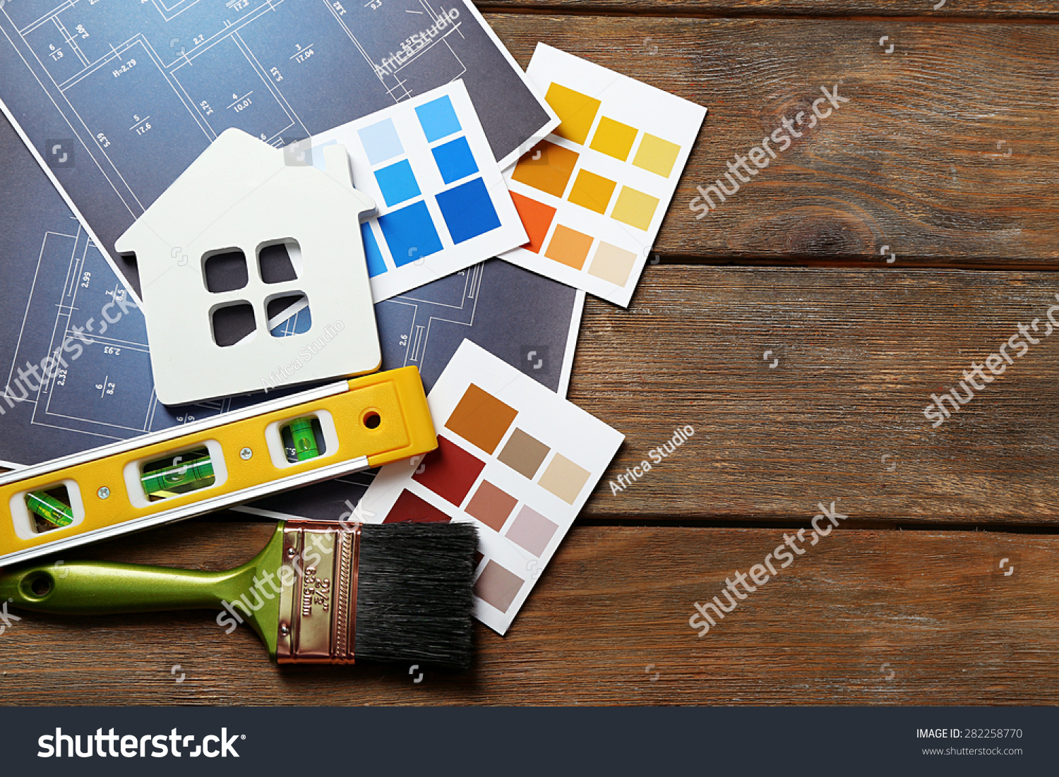 颜色样品,装饰房子,手套和画笔在木桌上的背景