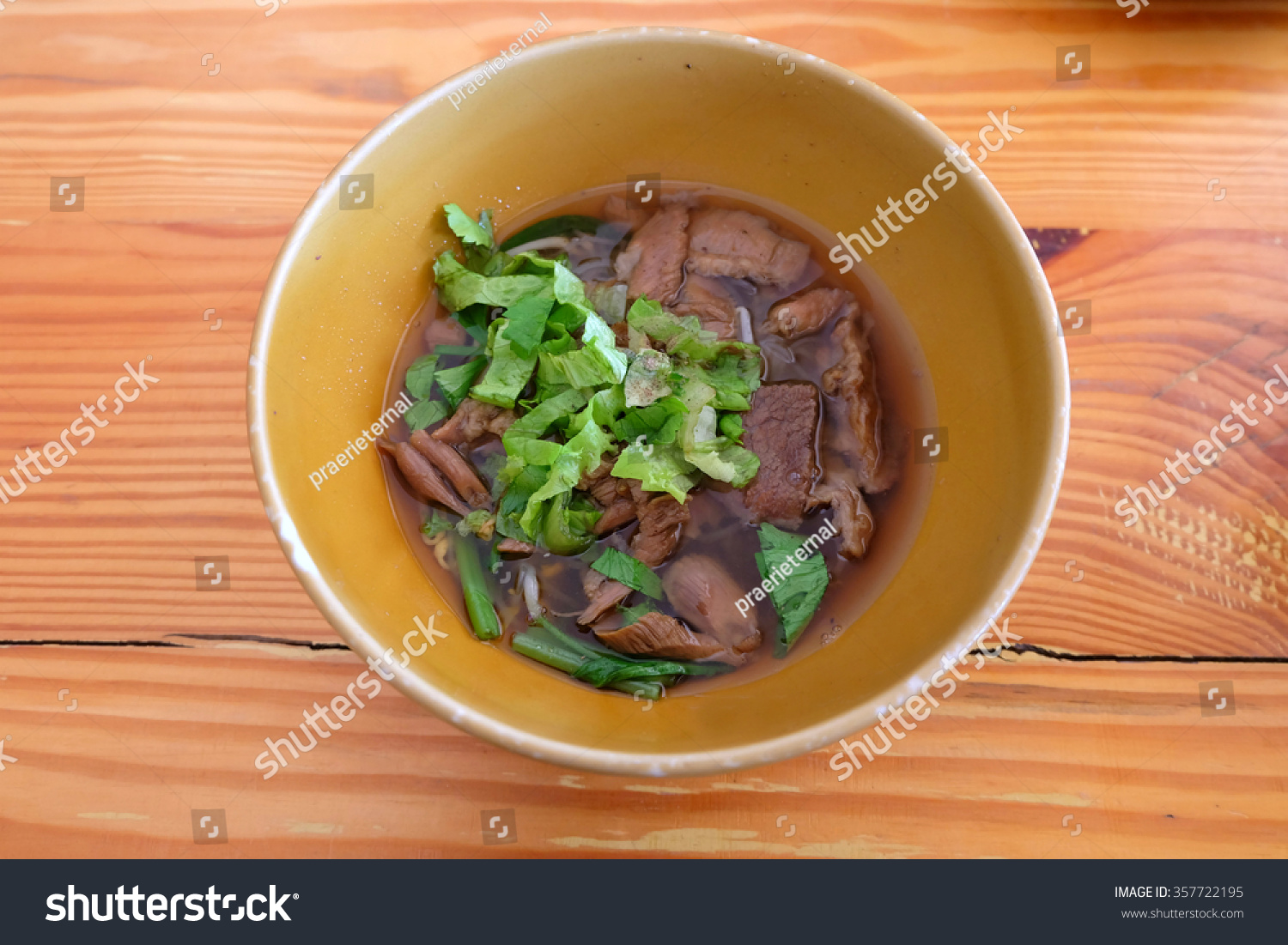 noodle and braised beef in bowl on wooden background.